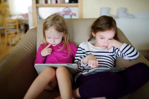 To piger læser bøger på tablet
