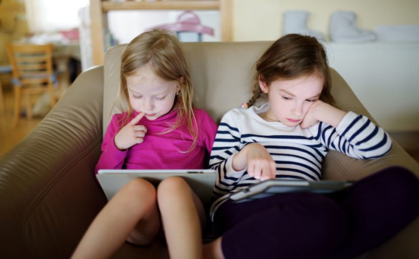 To piger læser bøger på tablet
